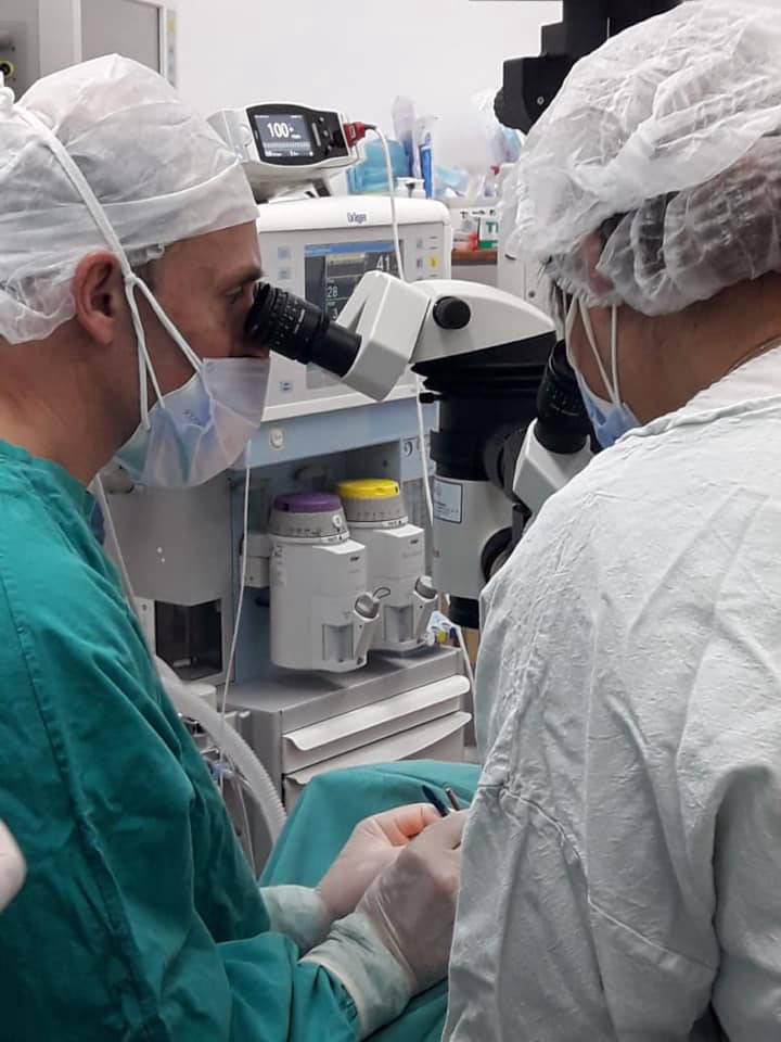 Equipo medico trabajando con microscopio quirurgico